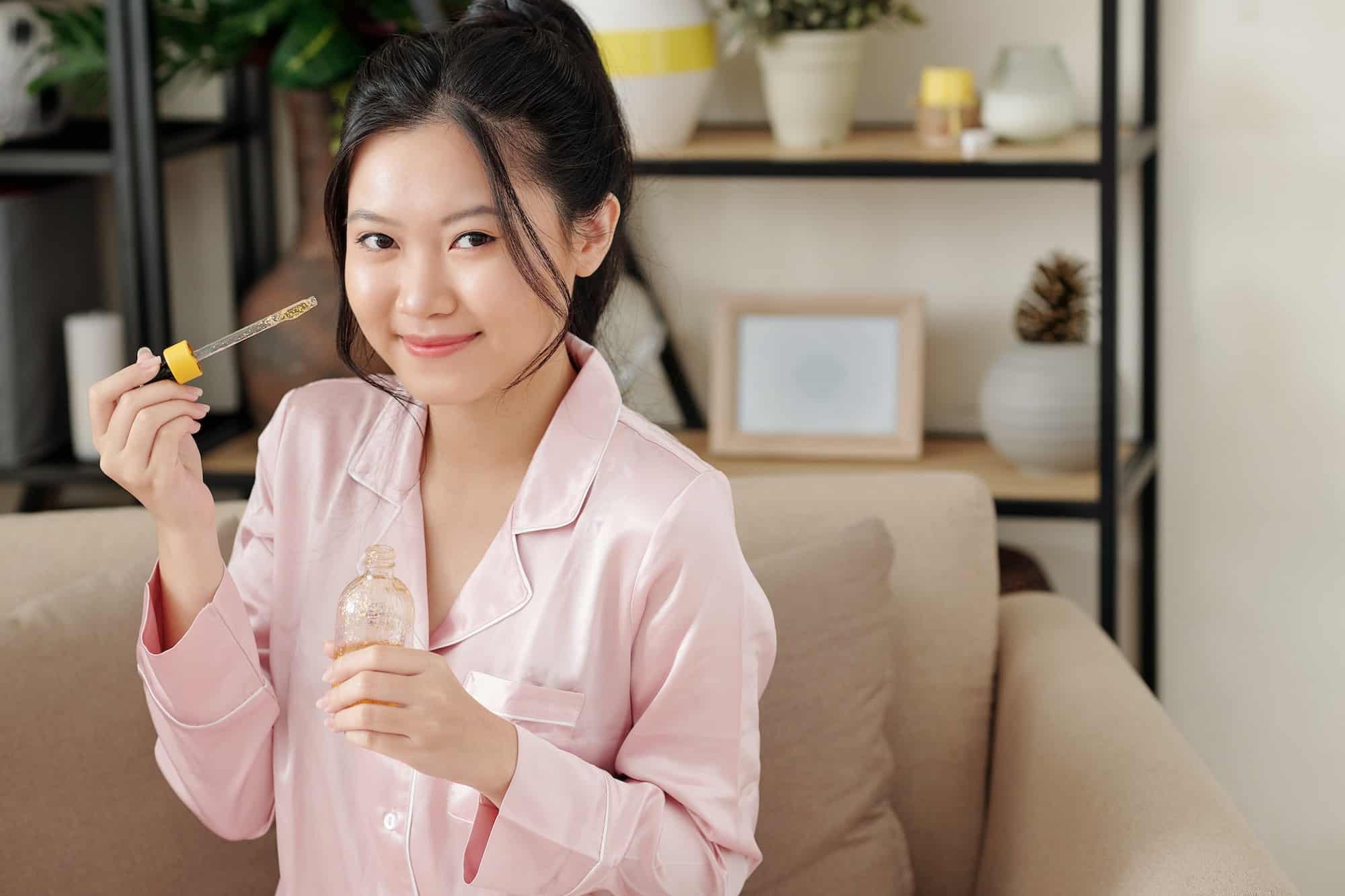 Woman applying serum with vitamin c