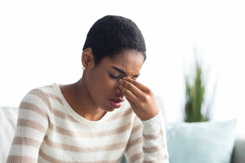 Sinusitis Concept. Sick Young Black Woman Touching Her Nose Bridge At Home
