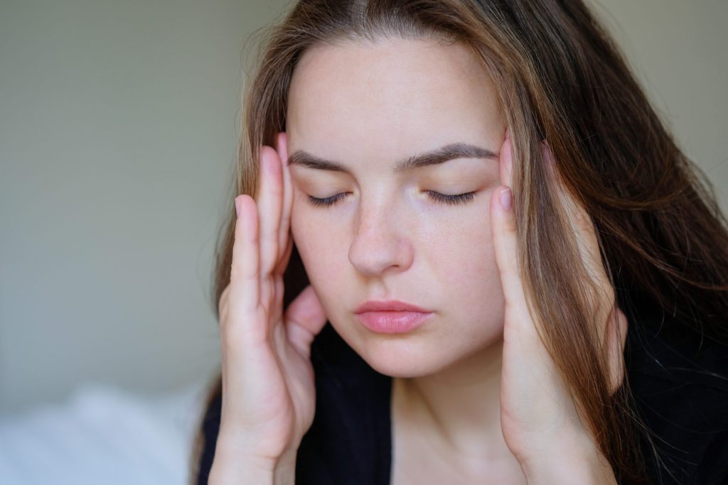 Portrait of woman with headache or migraine pain