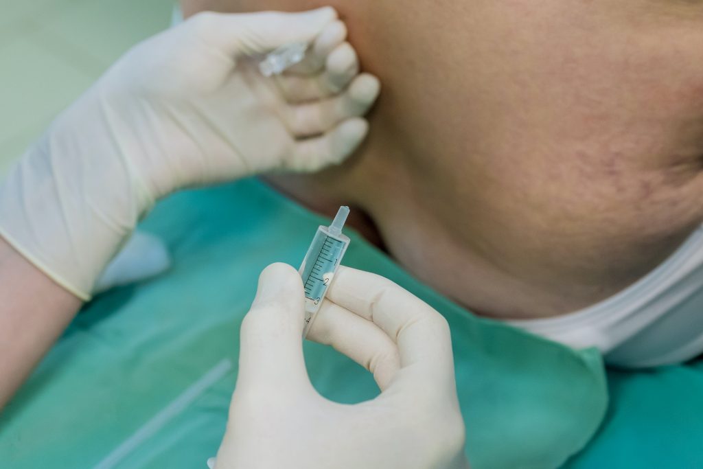 During procedure patient is positioned in sterile surgical room, typically on sitting up to allow