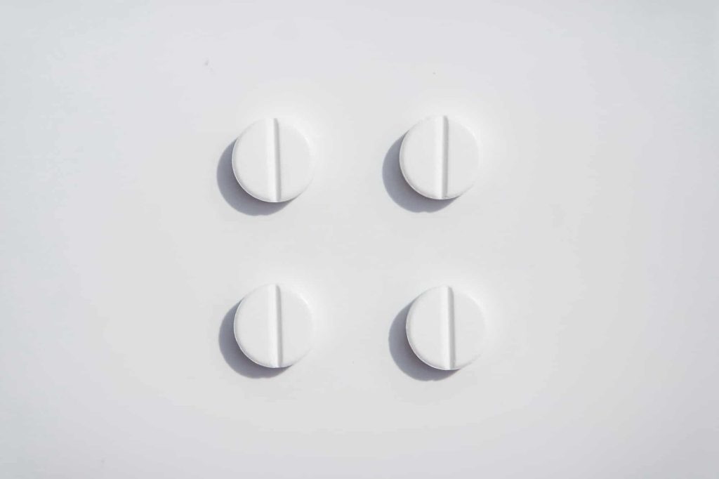 Four white pils on the white background tidy organized. Paracetamol
