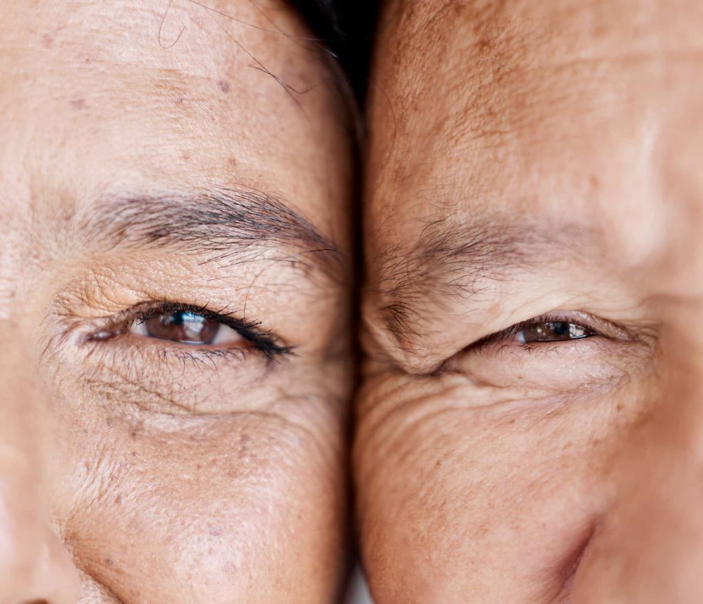 Love, eyes and half with a senior couple closeup, face touching skin wrinkles for romance in retire