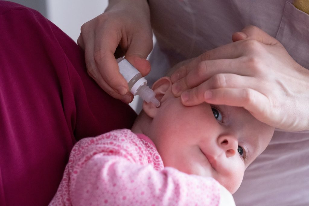 Mor gir øredråper til babyen.