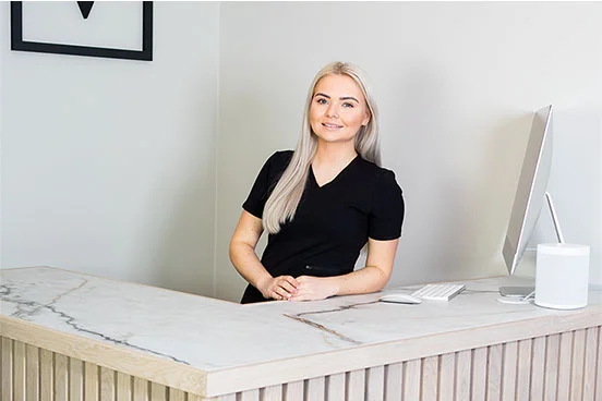 Sara smiler bredt foran kamera