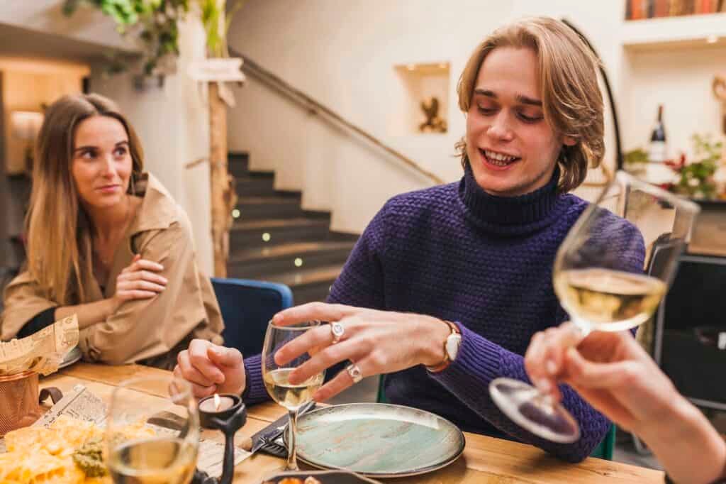 Group of smiling friends at a dinner table conversating