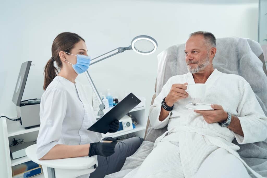 Man having consultation with doctor in cosmetology clinic
