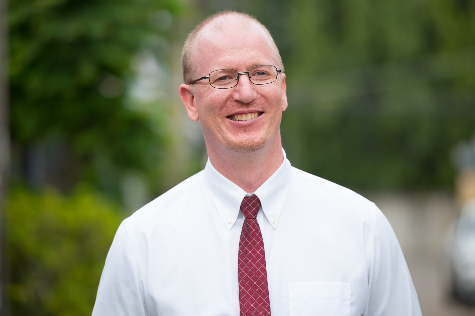 Portrait of happy mature bald businessman thinking outdoors