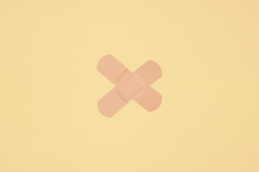 two strips of adhesive plaster tape on skin colored paper background