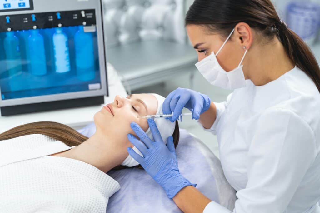 Caucasian woman being injected an under-eye filler