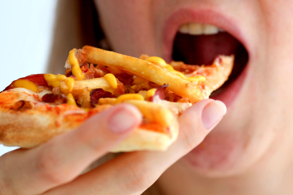Woman eats pizza, of mischievous calories and harmful cholesterol.
