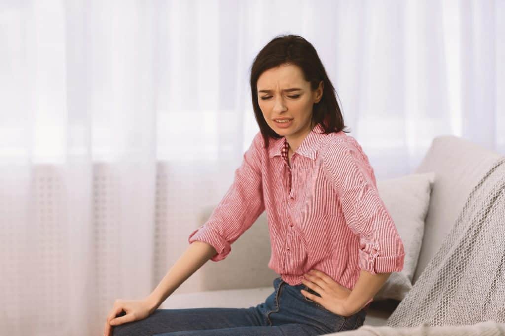 Young woman suffering from pain in side