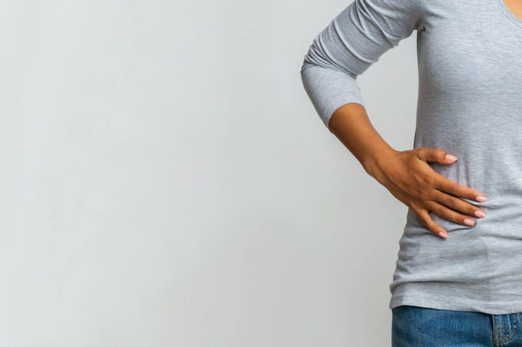 African woman suffering from liver pain, cropped