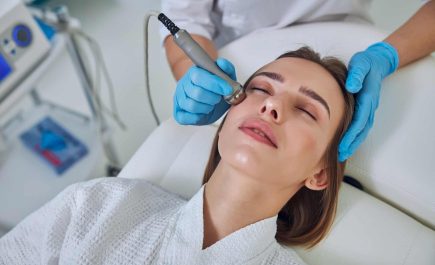 Adorable pretty lady receiving professional skin care with ultrasound device in beauty clinic