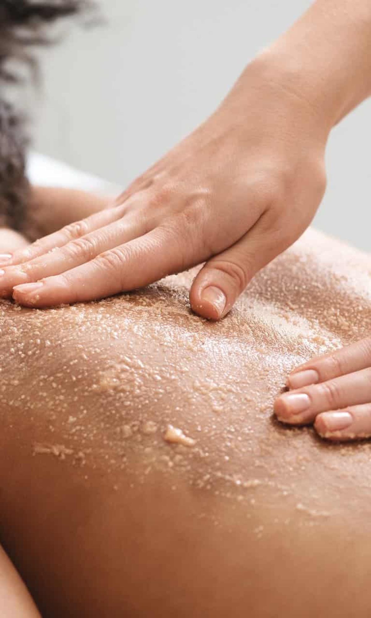 African american lady having skin scrubbing procedure at spa salon